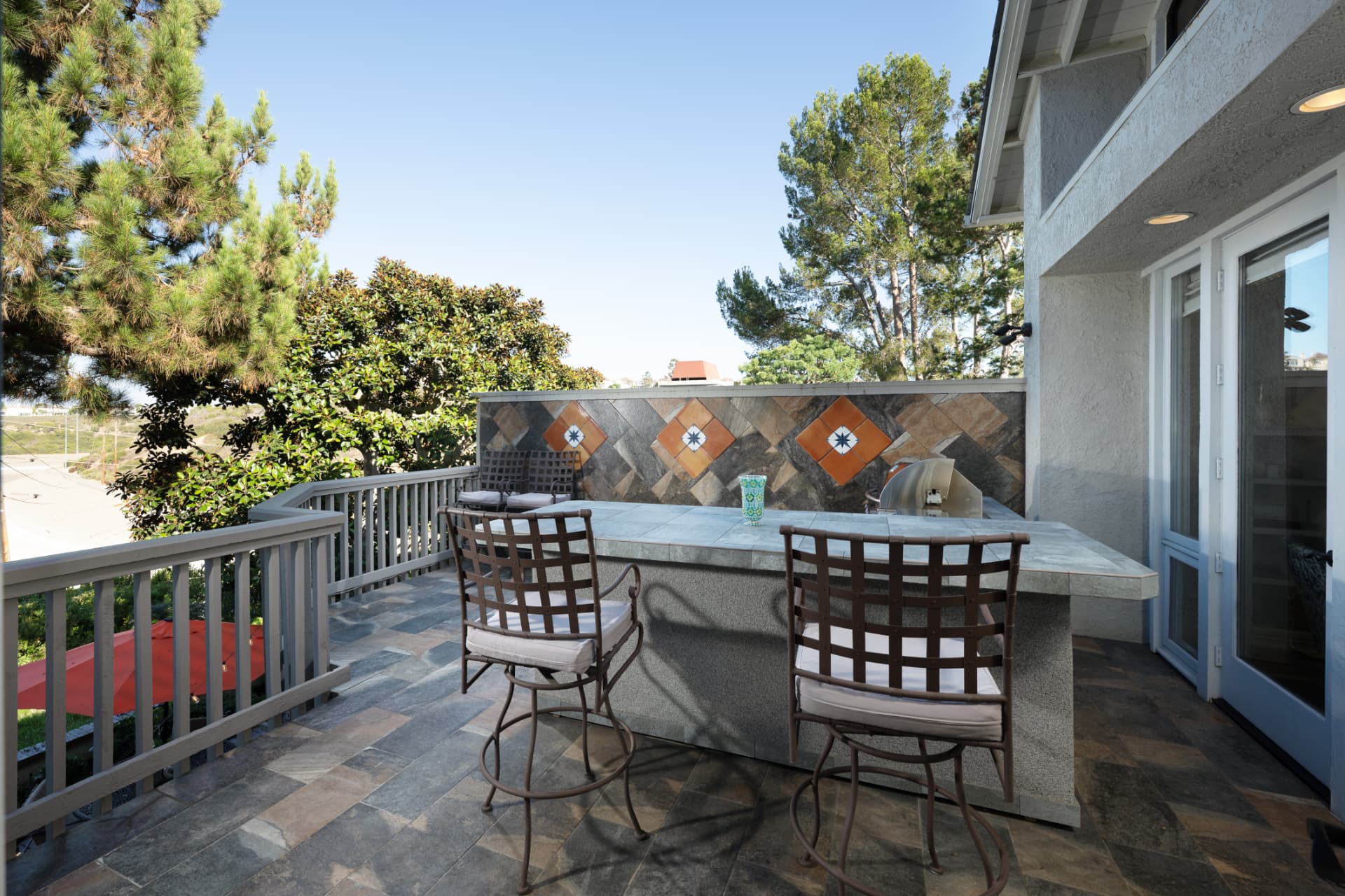 Outdoor BBQ counter with bar seating and decorative tile wall