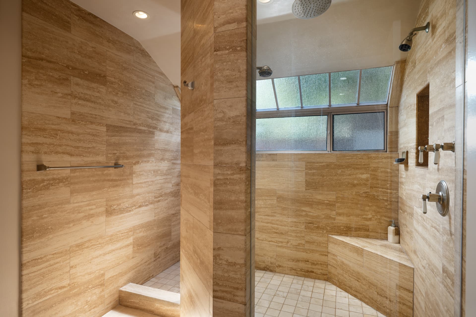 Travertine primary shower with rain head and clerestory windows