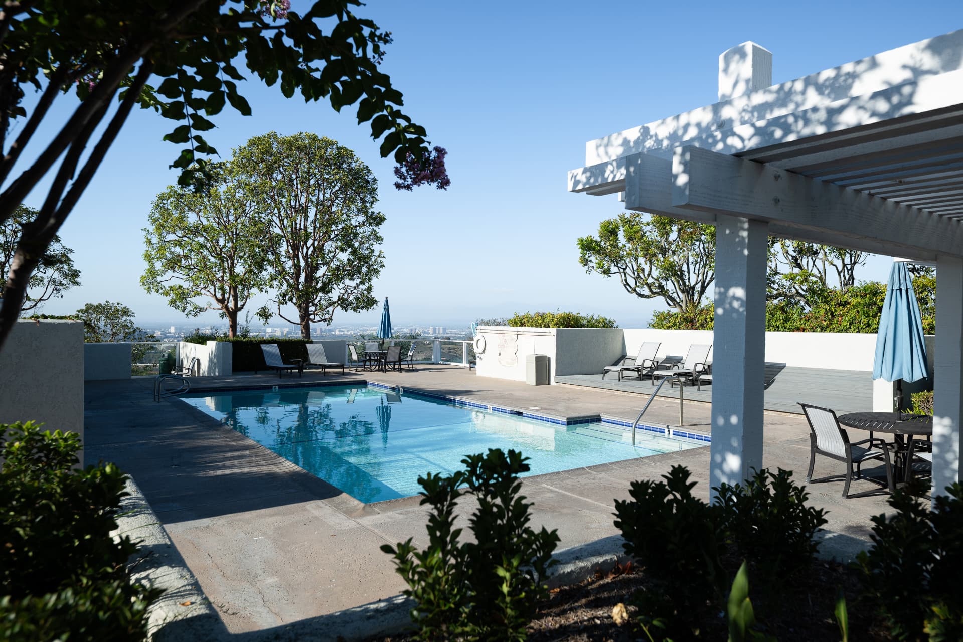 Shaded community pool under the white pergola