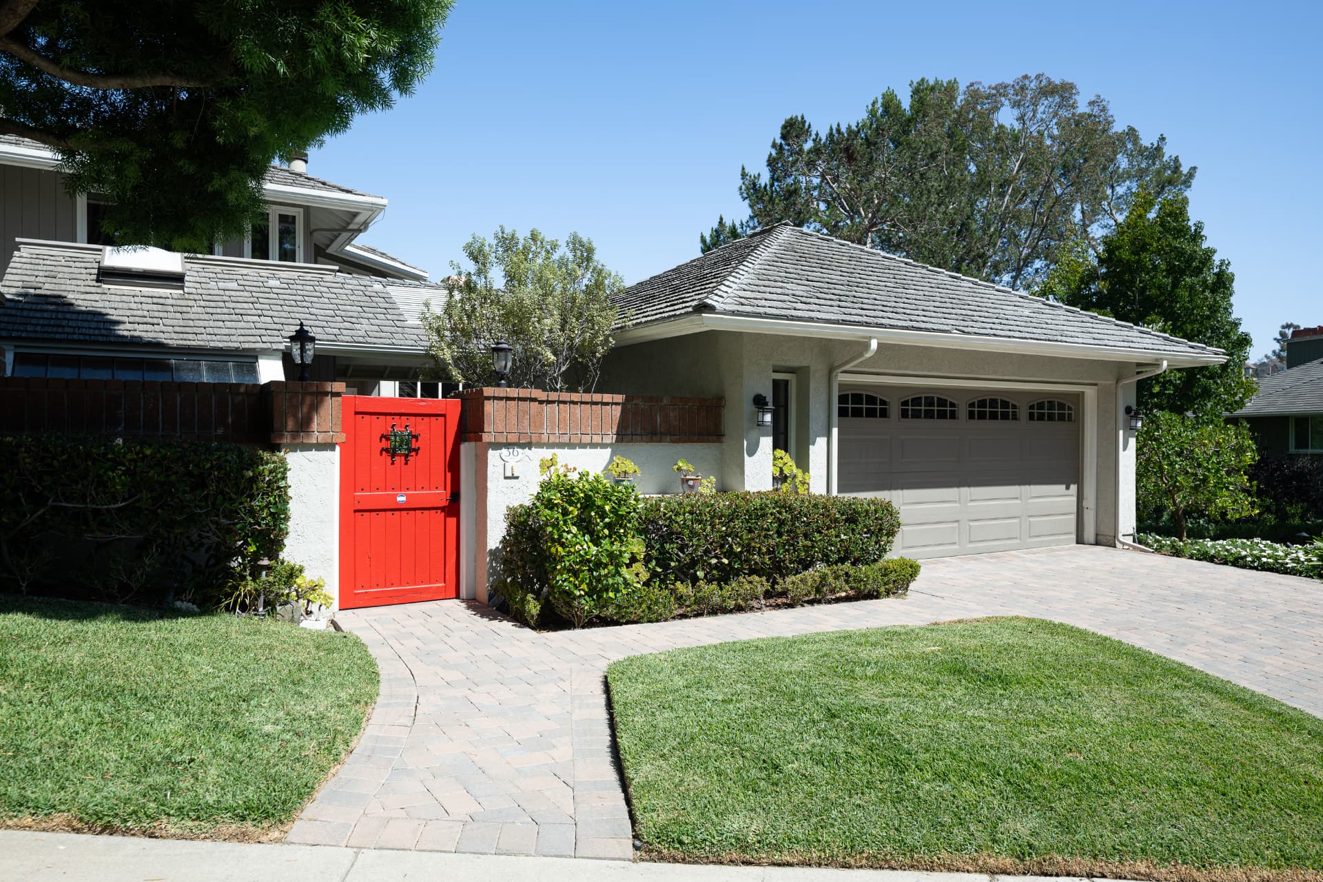 Street view of 36 Vienna with the iconic red gate and paver driveway